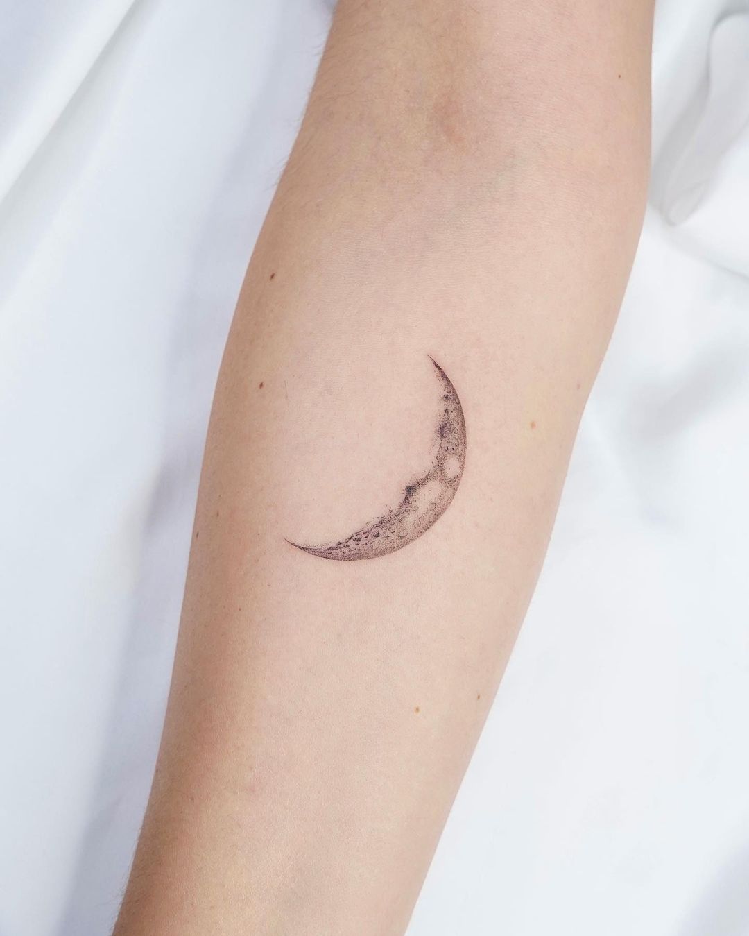 Delicate minimalistische maan tattoo