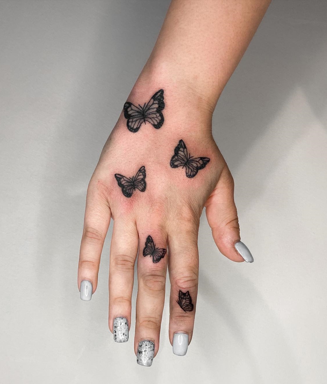 Butterfly Tattoo op middelste en wijsvingers