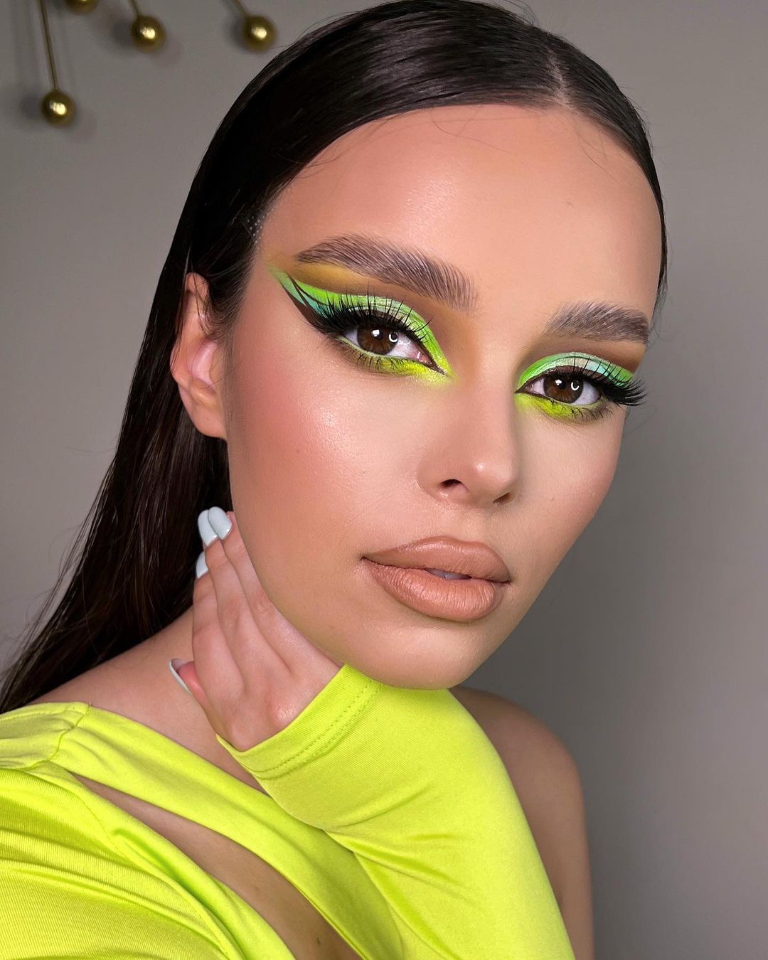 Groene oogschaduw make-up met pijlen voor bruine ogen