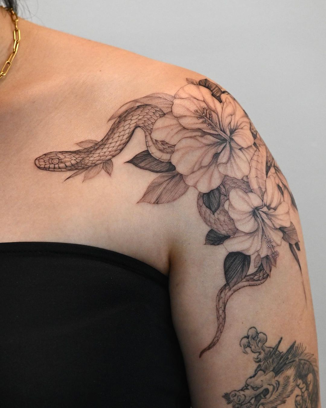 Zwart-witte Hibiscus Flower Tattoo met slang op schouder