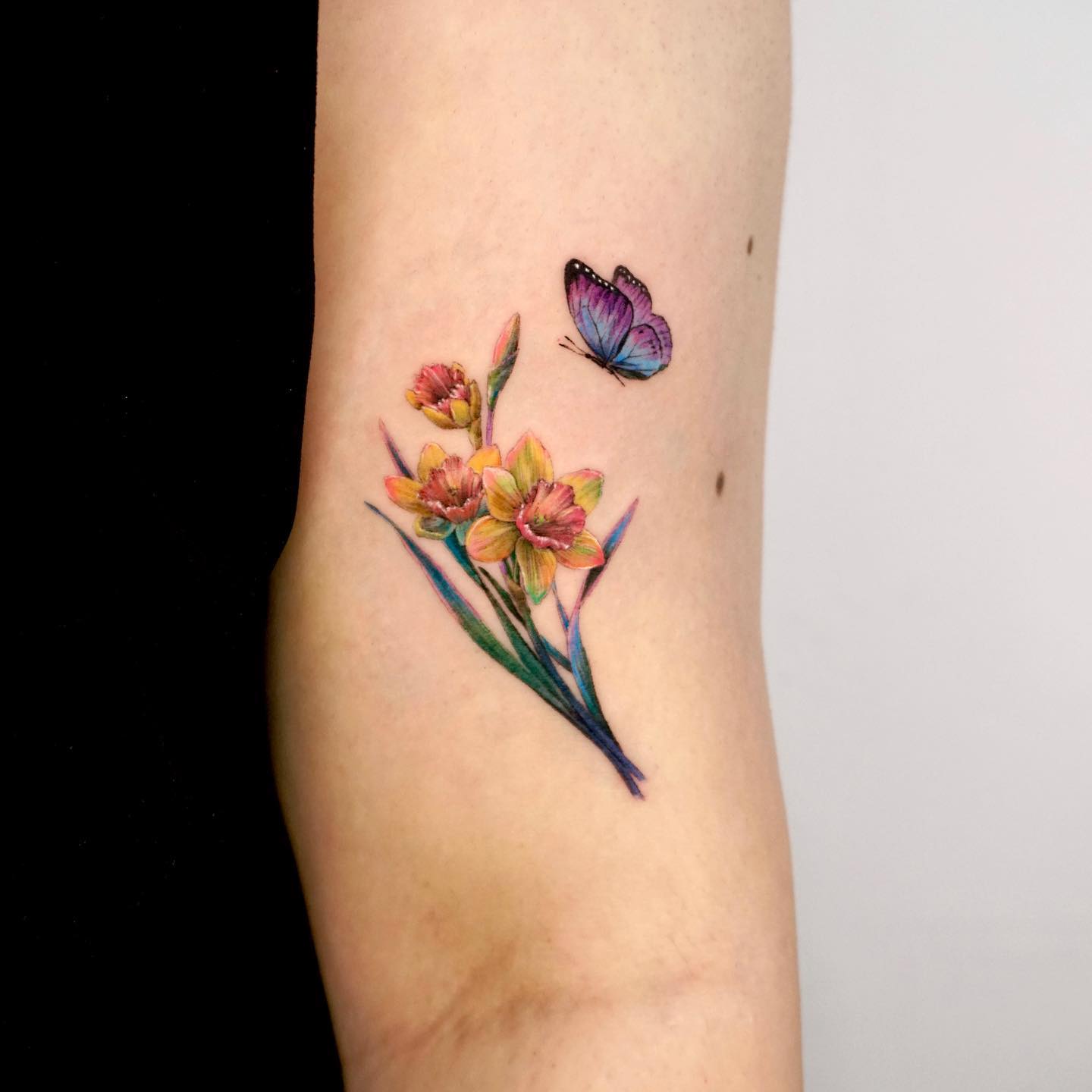 Kleur Narcissus Flower Tattoo met vlinder op arm