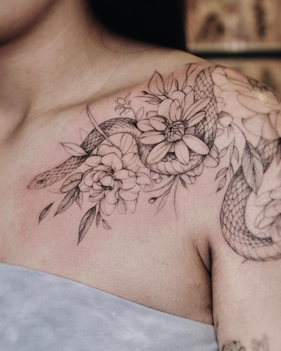 Zwart-witte slang en roos tattoo op schouder