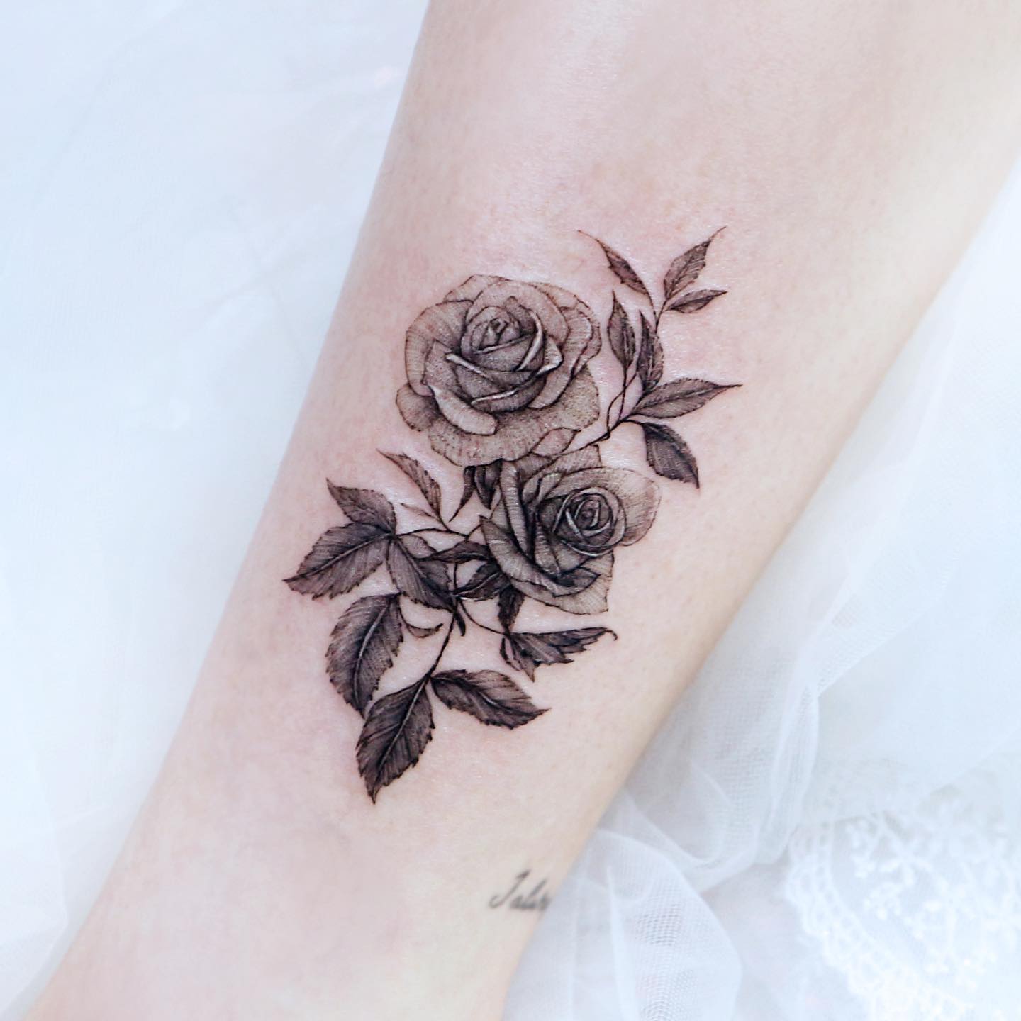 Zwart-witte rose tattoo op arm