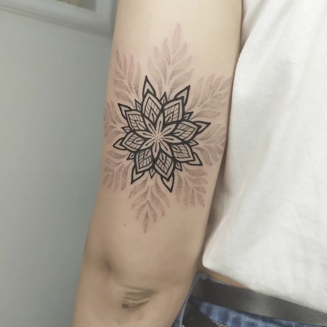 Zwart-witte geometrische bloem tattoo op arm