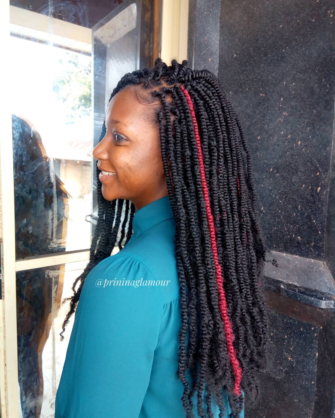 Nubische twists op lang zwart haar met rode streng