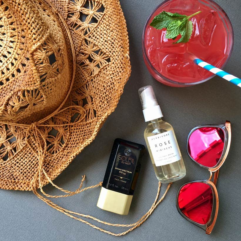 Soleil Toujours zonnebrandcrème flatlay foto van zwembad essentials zonnebril cocktail stro hoed